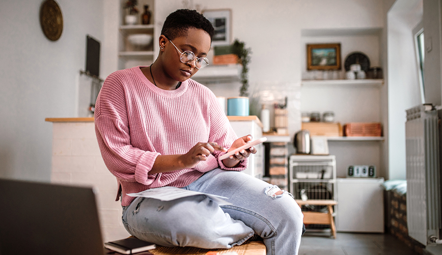 woman looking at phone sitting on coffee table